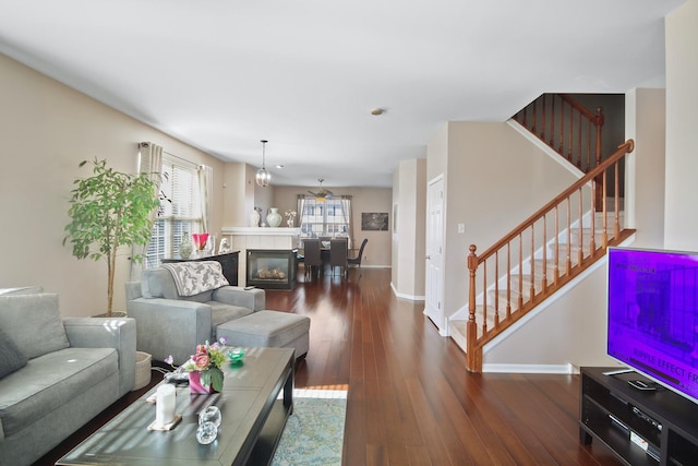 living room with wood-type flooring, baseboards, and stairs