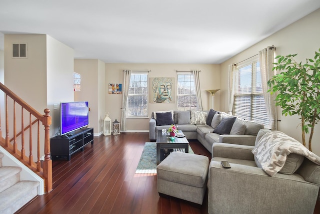 living room featuring stairs, hardwood / wood-style floors, visible vents, and baseboards