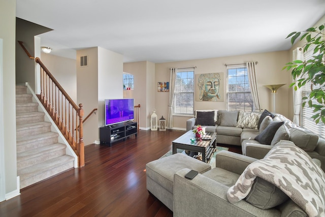 living room with visible vents, stairway, baseboards, and wood finished floors