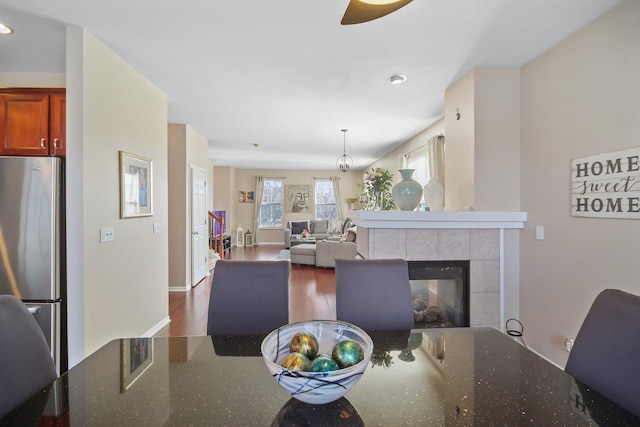 dining room with a fireplace, baseboards, and wood finished floors