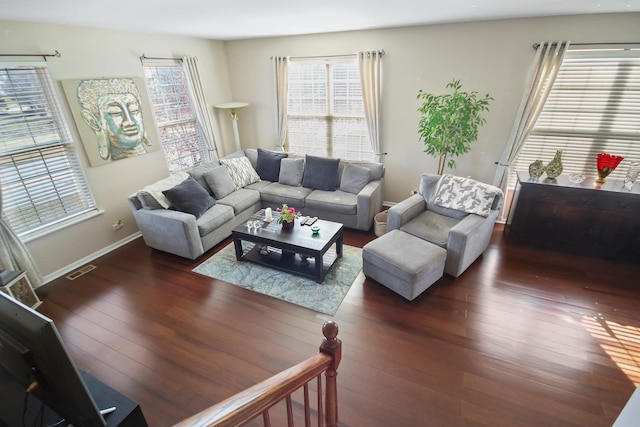 living room with baseboards, visible vents, and hardwood / wood-style floors