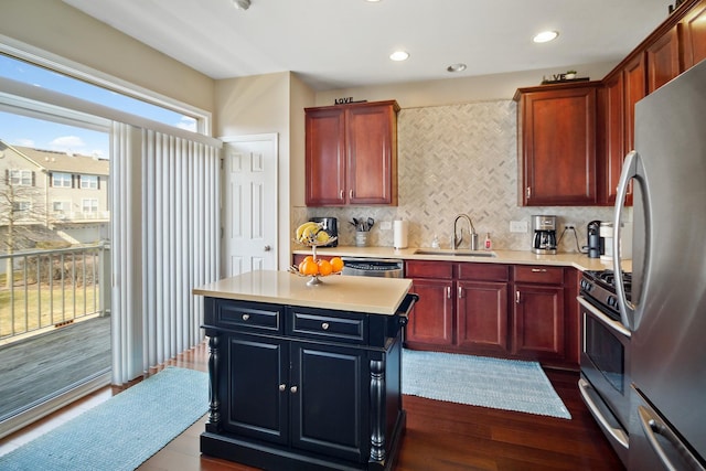 kitchen featuring dark wood-style flooring, a sink, light countertops, appliances with stainless steel finishes, and tasteful backsplash