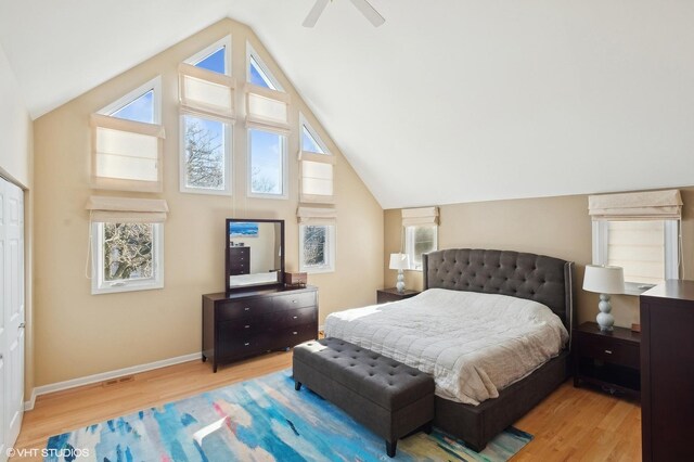 bedroom featuring visible vents, high vaulted ceiling, light wood-style floors, baseboards, and ceiling fan