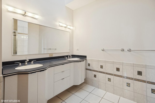 full bath with a sink, tile walls, tile patterned floors, and double vanity