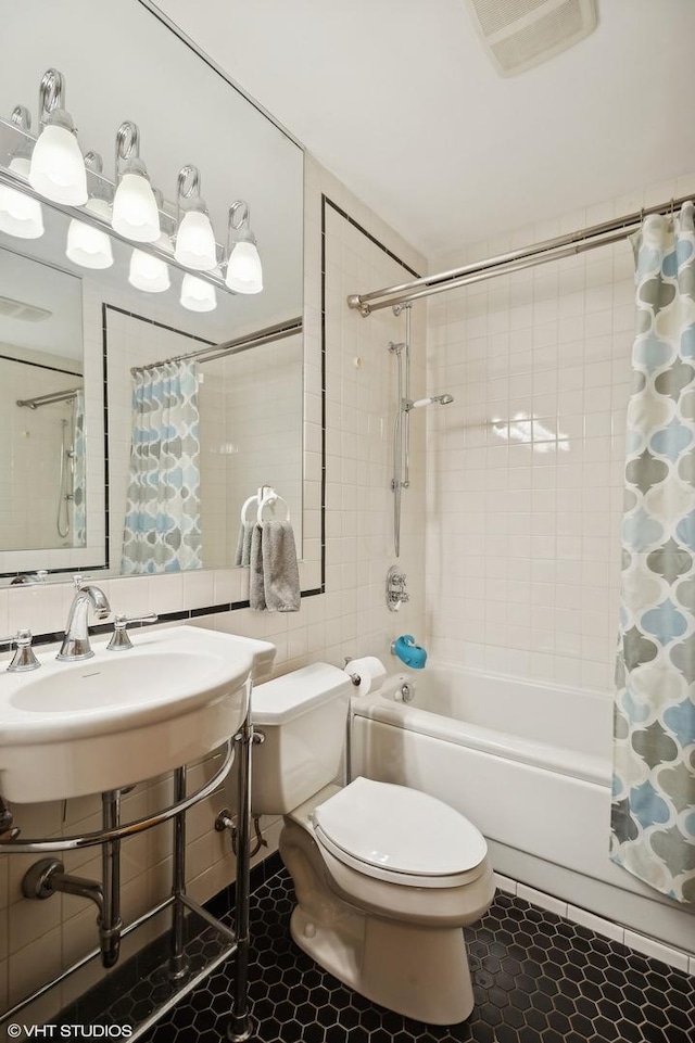 full bath with tile patterned flooring, visible vents, toilet, shower / tub combo, and tile walls