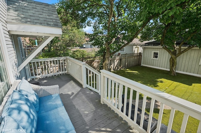 wooden deck with a yard, an outbuilding, and a fenced backyard