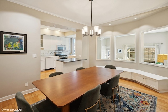 dining space with recessed lighting, baseboards, an inviting chandelier, and light wood finished floors