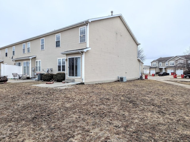 rear view of property featuring entry steps, a patio area, and central AC