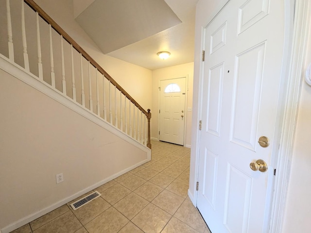 foyer entrance featuring visible vents, stairway, baseboards, and light tile patterned floors