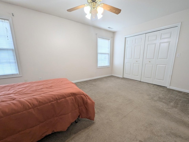 bedroom featuring baseboards, visible vents, a ceiling fan, carpet flooring, and a closet