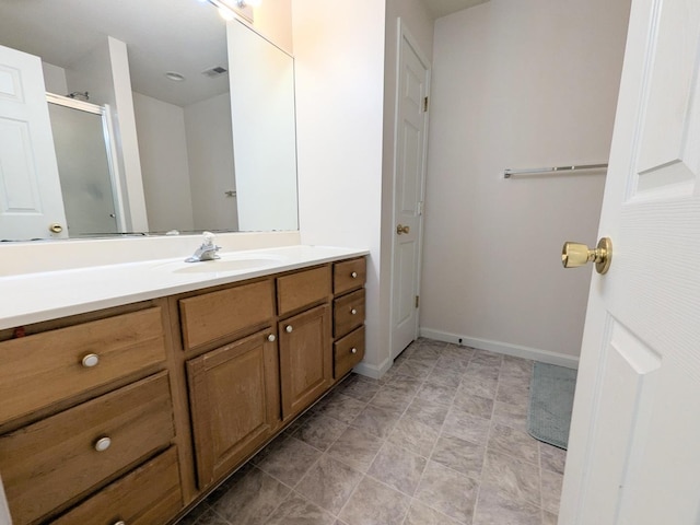 bathroom with visible vents, a shower stall, vanity, and baseboards