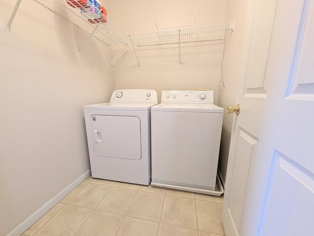 laundry room featuring laundry area, independent washer and dryer, baseboards, and light tile patterned floors