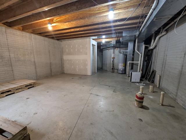 unfinished below grade area with water heater and brick wall