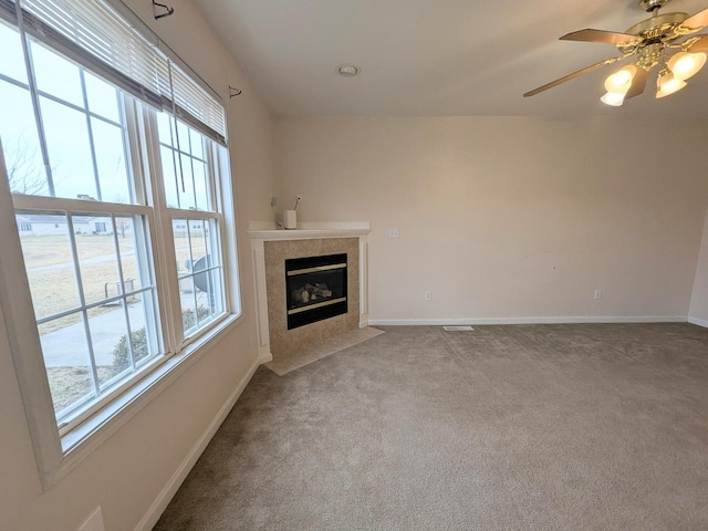 unfurnished living room with carpet floors, visible vents, a fireplace, and baseboards