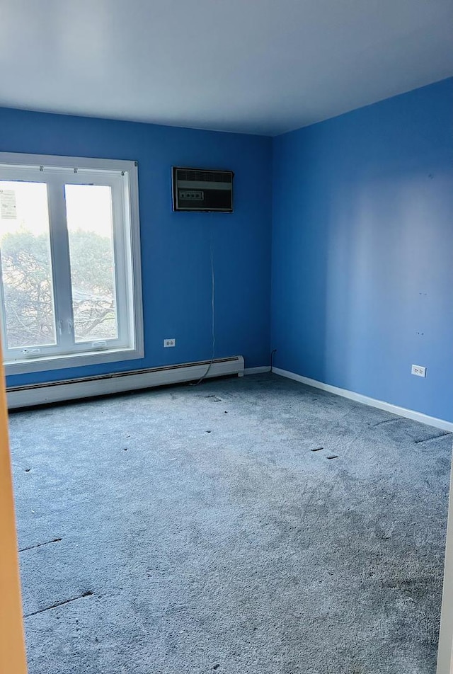 spare room with carpet, baseboards, a wall mounted air conditioner, and baseboard heating