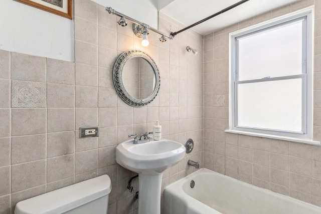 bathroom featuring a sink, plenty of natural light, toilet, and tile walls