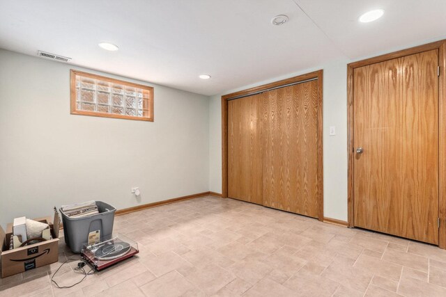 unfurnished bedroom with baseboards, visible vents, a wood stove, recessed lighting, and a closet