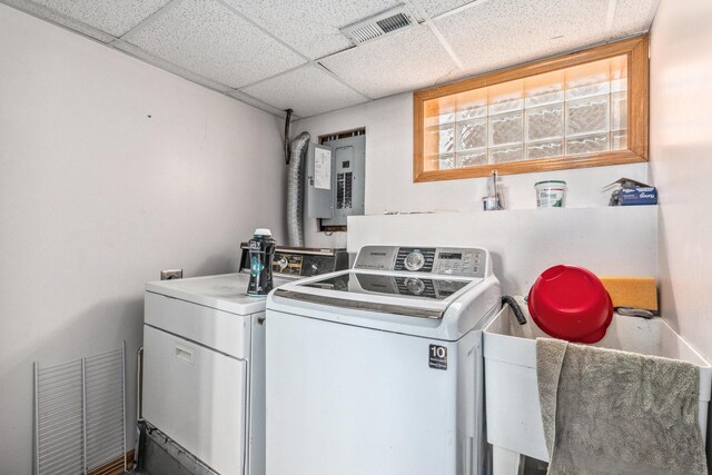 clothes washing area with washing machine and clothes dryer, laundry area, electric panel, and visible vents