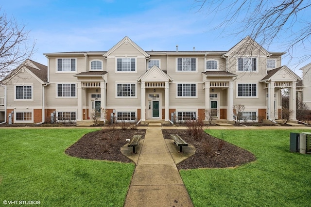 view of front of house with brick siding and a front yard