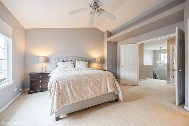 bedroom featuring lofted ceiling, baseboards, a ceiling fan, and light colored carpet