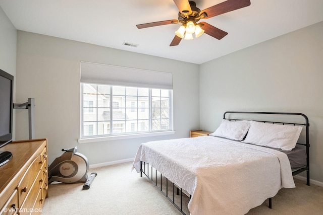 carpeted bedroom with a ceiling fan, visible vents, and baseboards