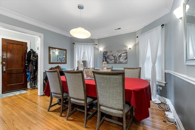 dining area featuring ornamental molding, a wealth of natural light, and light wood-style floors