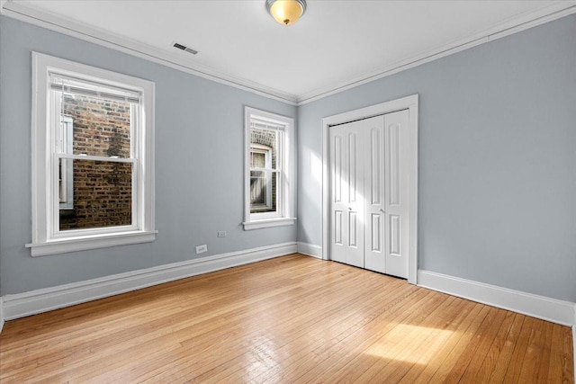 unfurnished bedroom featuring crown molding, baseboards, visible vents, and light wood-style floors