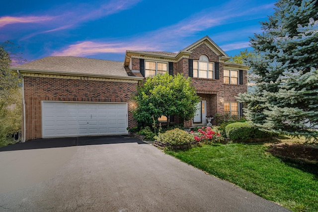 colonial house featuring a garage, aphalt driveway, and brick siding