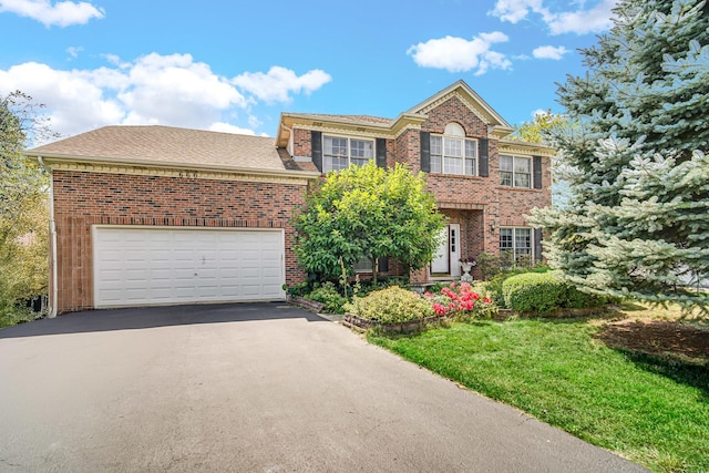 colonial-style house with driveway, brick siding, roof with shingles, and an attached garage