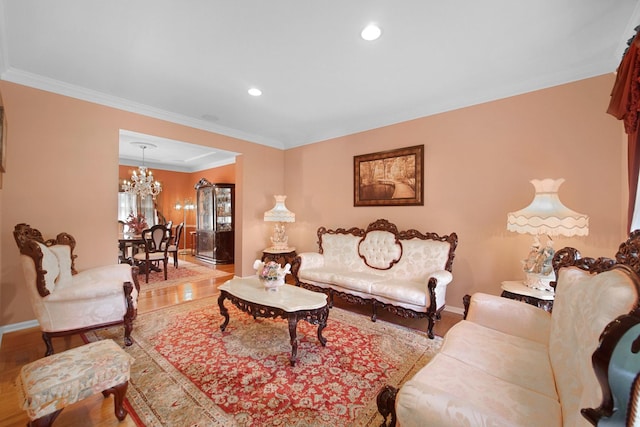 living area featuring ornamental molding, wood finished floors, baseboards, and an inviting chandelier