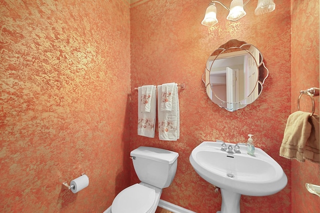 bathroom featuring a sink, toilet, and baseboards