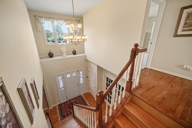 entryway with a notable chandelier, baseboards, and wood finished floors