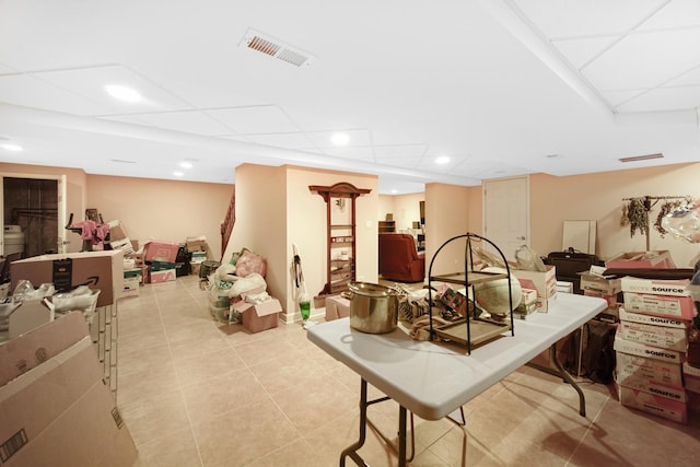 finished basement featuring light tile patterned floors, visible vents, a drop ceiling, and recessed lighting