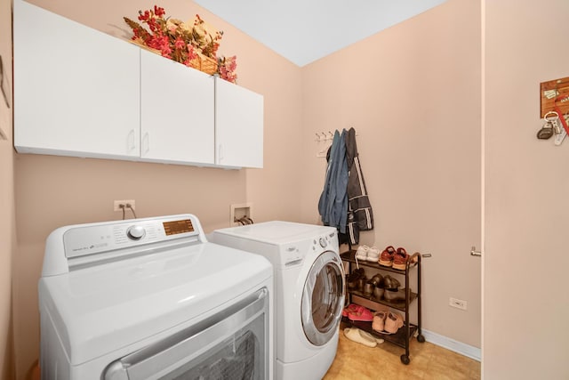 laundry room with washer and clothes dryer, cabinet space, and baseboards