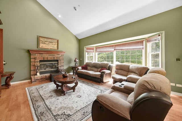 living room with light wood-style floors, plenty of natural light, and a brick fireplace