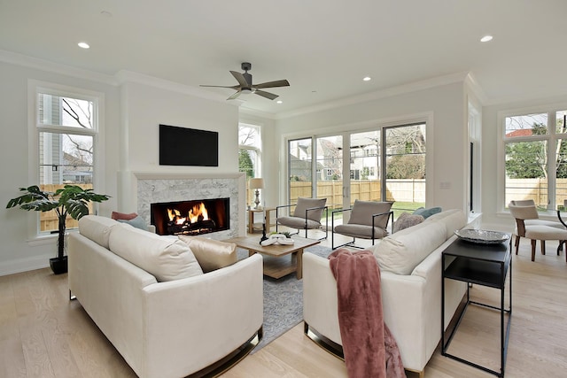 living area with a fireplace, a wealth of natural light, and light wood-style floors