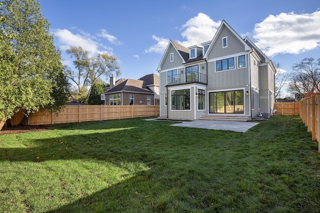 rear view of house featuring board and batten siding, a patio area, a fenced backyard, and a lawn