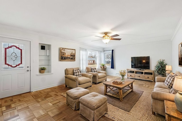 living room featuring crown molding, baseboards, and ceiling fan