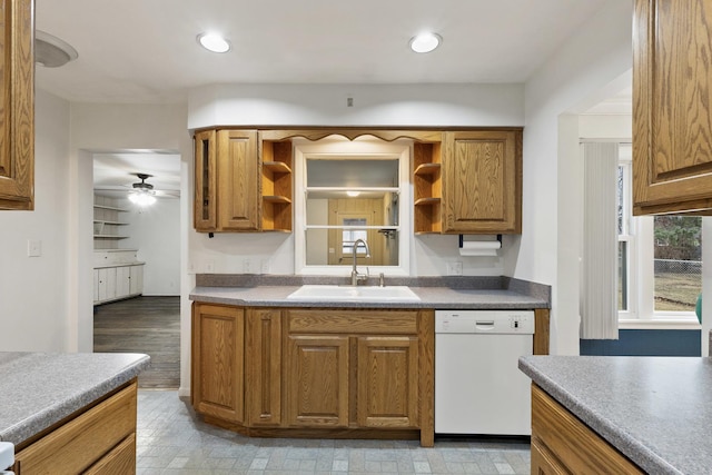 kitchen with brown cabinets, a ceiling fan, a sink, open shelves, and white dishwasher