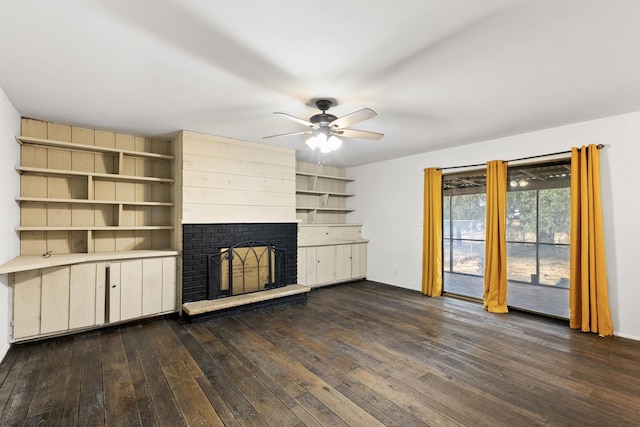 unfurnished living room featuring a brick fireplace, ceiling fan, and dark wood-style flooring