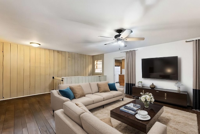 living room featuring wood walls, ceiling fan, and hardwood / wood-style floors