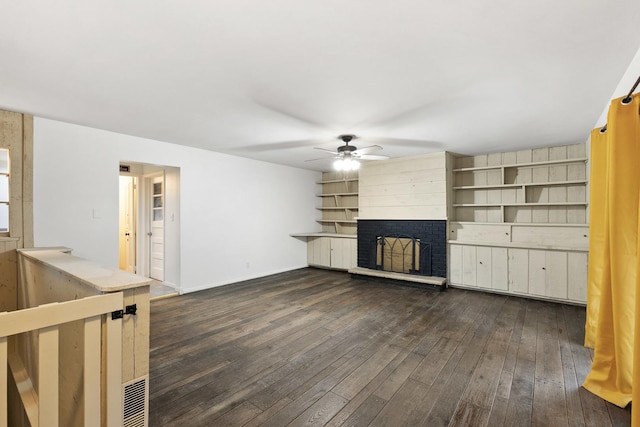 unfurnished living room with dark wood-type flooring, ceiling fan, and a fireplace