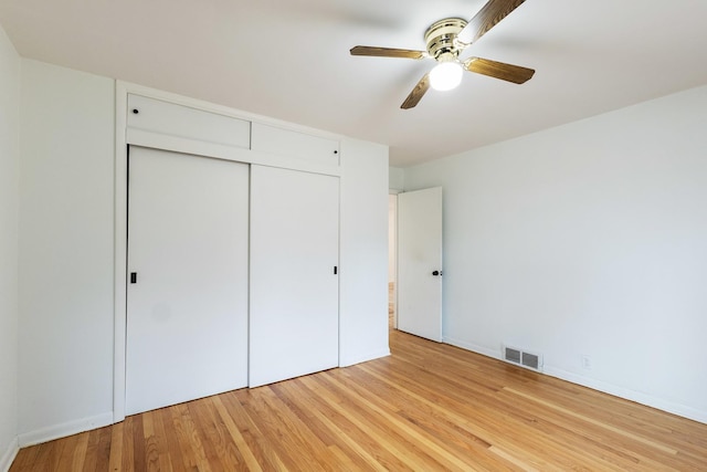 unfurnished bedroom featuring visible vents, a closet, light wood-style floors, baseboards, and ceiling fan