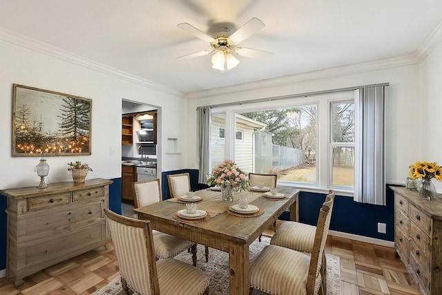 dining space featuring baseboards, ceiling fan, and crown molding