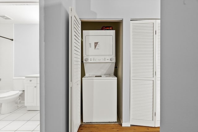 laundry area featuring laundry area, stacked washing maching and dryer, and visible vents