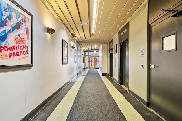 hall with ornamental molding, wood ceiling, and baseboards