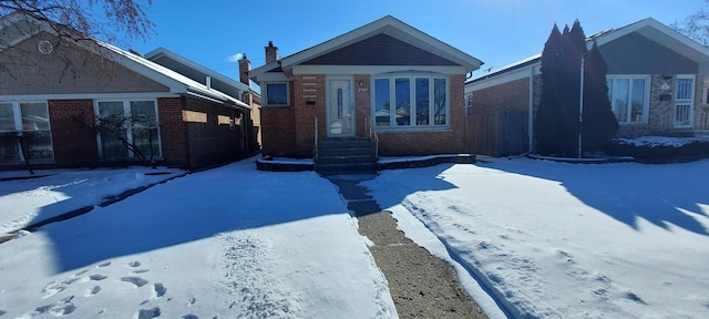 view of front of property featuring brick siding and a chimney