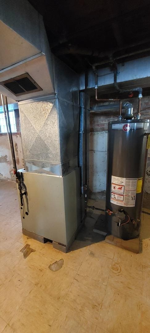 utility room with heating unit, water heater, and visible vents