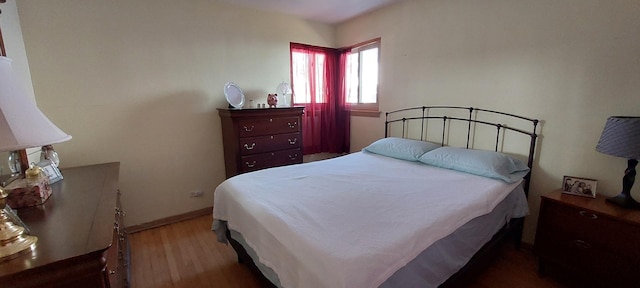 bedroom featuring baseboards and wood finished floors