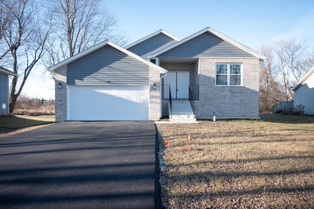 view of front of home with driveway, a garage, a front lawn, and brick siding